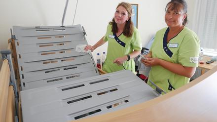 Pflegekraft Galina Hlinov und Pflegefachkraft Madlen Hennig (r.) reinigen ein Bewohnerbett im Lafim-Seniorenzentrum Templin.