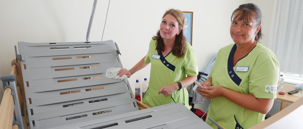 Pflegekraft Galina Hlinov und Pflegefachkraft Madlen Hennig (r.) reinigen ein Bewohnerbett im Lafim-Seniorenzentrum Templin.