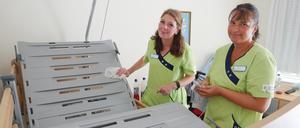 Pflegekraft Galina Hlinov und Pflegefachkraft Madlen Hennig (r.) reinigen ein Bewohnerbett im Lafim-Seniorenzentrum Templin.