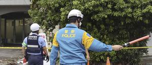 Polizisten stehen vor einem beschädigten Gebäude nach einem Erdbeben in Miyazaki. 