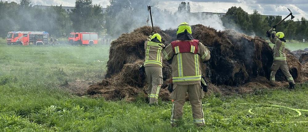 Einsatzkräfte von Freiwilligen Feuerwehren löschten den Brand der Heuballen