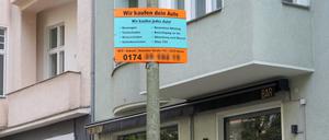 Mit illegalen Plakaten an Berliner Laternen werben Autohändler für den Ankauf von Fahrzeugen.