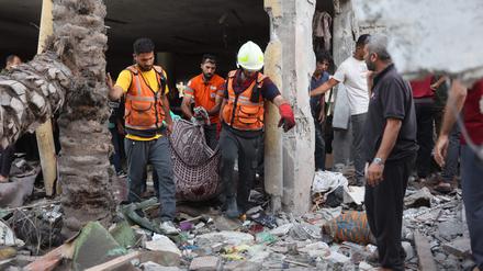 Hilfskräfte tragen in Gaza nach einem israelischen Luftangriff eine Leiche aus einem zerstörten Gebäude.