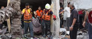 Hilfskräfte tragen in Gaza nach einem israelischen Luftangriff eine Leiche aus einem zerstörten Gebäude.