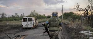 Ukraine, Tschassiw Jar: Auf diesem vom Pressedienst der 24. Mechanisierten Brigade der Ukraine via AP zur Verfügung gestellten Foto läuft ein Soldat an einem beschädigten Auto vorbei (Archivbild vom 07.08.2024).