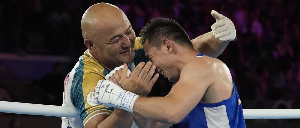 Hasanboy Dusmatov (r) feiert mit seinem Trainer Tulkin Kilichev, nachdem er das Finale gewonnen hat. 