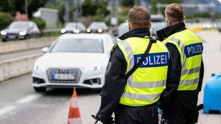 Deutsche Bundespolizisten beobachten an der Grenze zu Österreich auf der Autobahn A93 den Verkehr. 