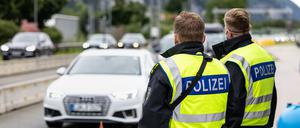 Deutsche Bundespolizisten beobachten an der Grenze zu Österreich auf der Autobahn A93 den Verkehr. 