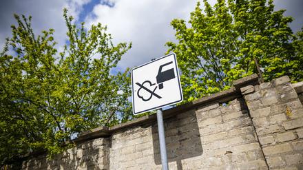 Ein Verkehrsschild mit einer durchgestrichenen Abgaswolke weist Verkehrsteilnehmende darauf hin, nicht den Motor laufen zu lassen.