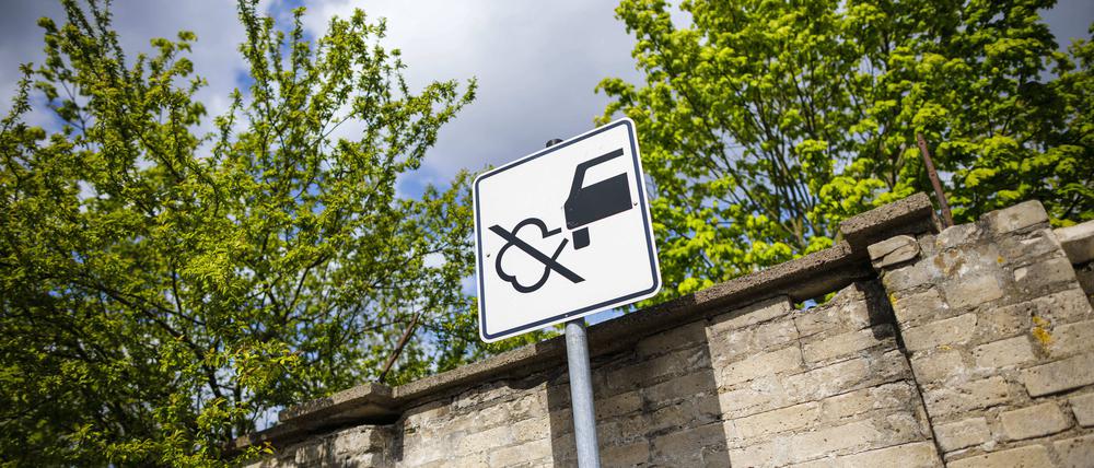 Ein Verkehrsschild mit einer durchgestrichenen Abgaswolke weist Verkehrsteilnehmende darauf hin, nicht den Motor laufen zu lassen.