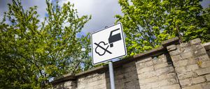 Ein Verkehrsschild mit einer durchgestrichenen Abgaswolke weist Verkehrsteilnehmende darauf hin, nicht den Motor laufen zu lassen.