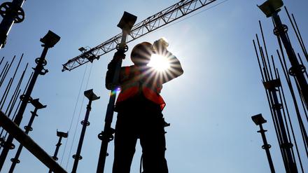 China, Zhengzhou: Ein Arbeiter trinkt Mungobohnensuppe, um sich vor der Hitze auf einer Baustelle in Zhengzhou in der zentralchinesischen Provinz Henan abzukühlen.