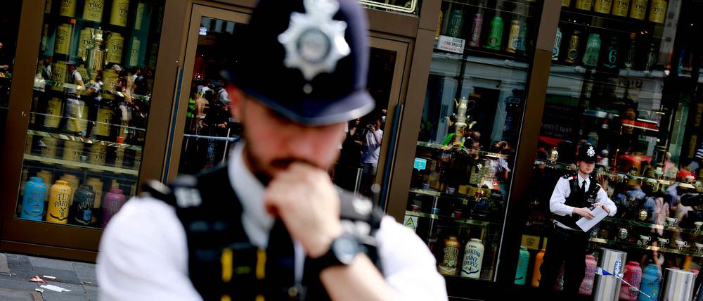 Polizisten stehen am Leicester Square in London.
