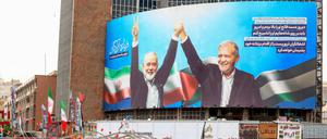 Hamas-Chef Ismail Hanija (links auf dem Bild) und Irans Präsident Massud Peseschkian auf einer Leinwand in Teheran.
