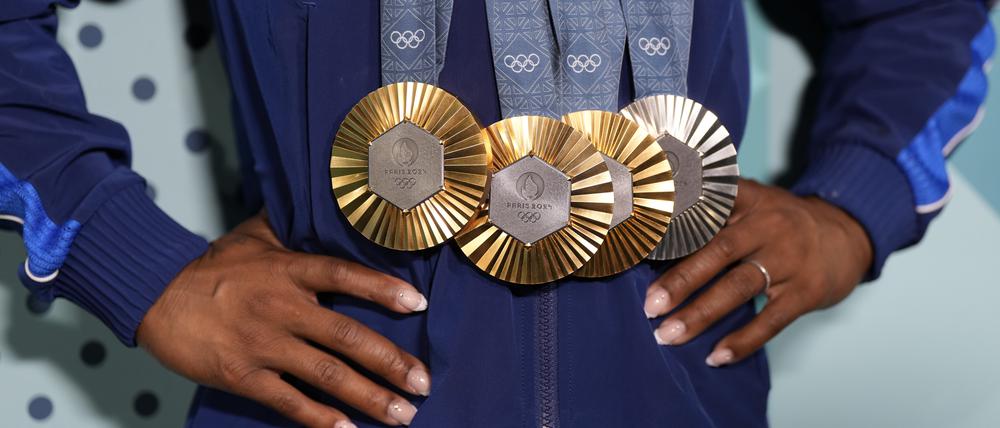 Simone Biles aus den USA zeigt ihre Medaillen nach dem Finale im Einzelgeräteturnen der Frauen in der Bercy Arena in Paris.