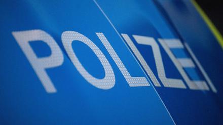 Das Wort Polizei ist auf der Karosserie eines Polizeifahrzeugs zu sehen (Symbolbild)