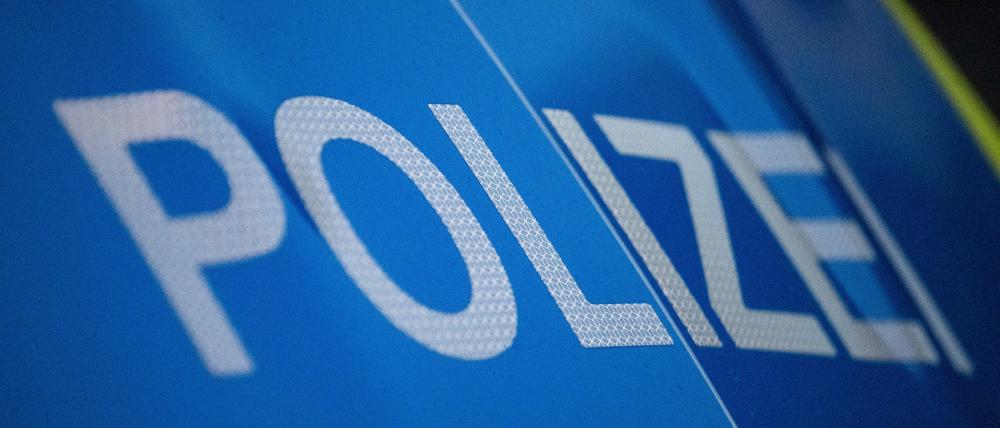 Das Wort Polizei ist auf der Karosserie eines Polizeifahrzeugs zu sehen (Symbolbild)