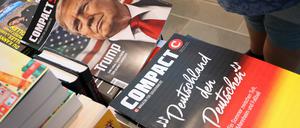 ARCHIV - 16.07.2024, Bayern, Kempten: Eine Mitarbeiterin einer Bahnhofsbuchhandlung hält eine Ausgabe des Magazins «Compact», um es danach aus dem Sortiment zu nehmen. Bundesinnenministerin Faeser hat das vom Bundesamt für Verfassungsschutz als rechtsextremistisch eingestufte «Compact»-Magazin sowie die Conspect Film GmbH verboten. (zu dpa: «Rechtsextremes Magazin «Compact» klagt gegen Verbot») Foto: Karl-Josef Hildenbrand/dpa +++ dpa-Bildfunk +++