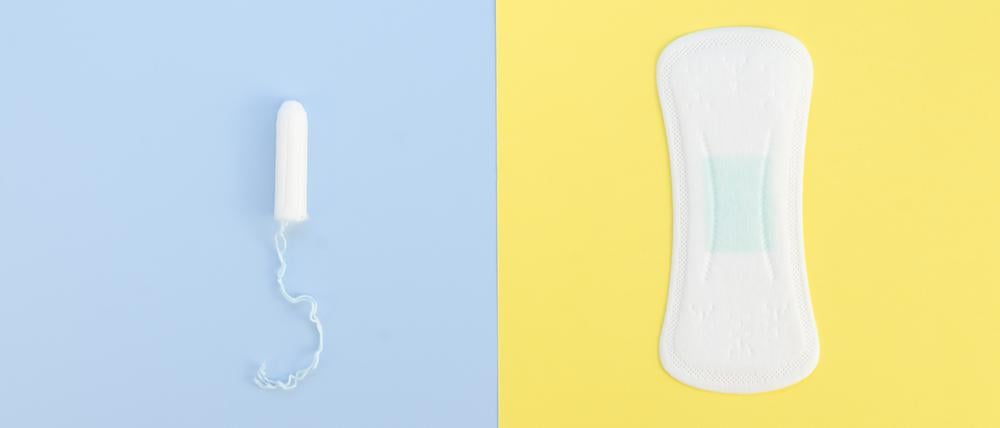Ein Tampon und eine Slipeinlage auf blauem und gelbem Untergrund.
