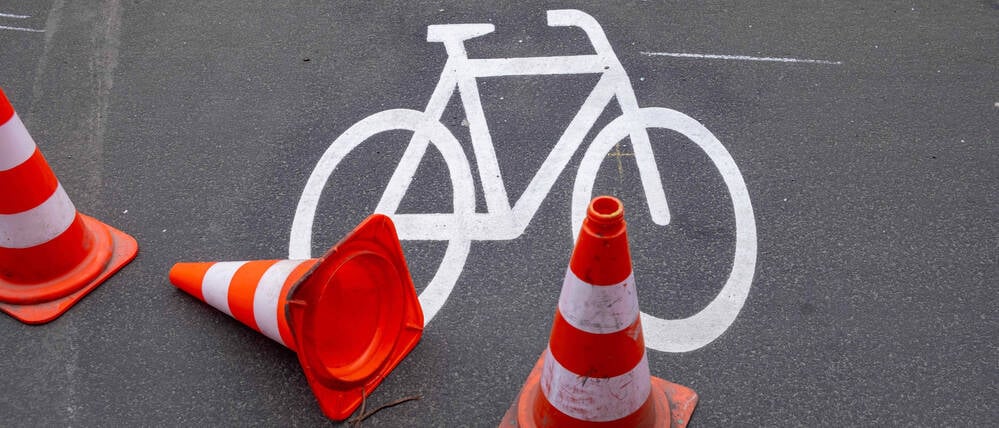 Leitkegel sichern ein frisch gemaltes Fahrradsymbol