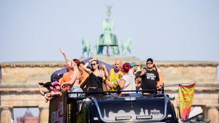 Menschen feiern bei der Technoparade «Rave the Planet» auf einem Wagen vor der Quadriga des Brandenburger Tors. 