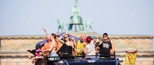 Menschen feiern bei der Technoparade «Rave the Planet» auf einem Wagen vor der Quadriga des Brandenburger Tors. 