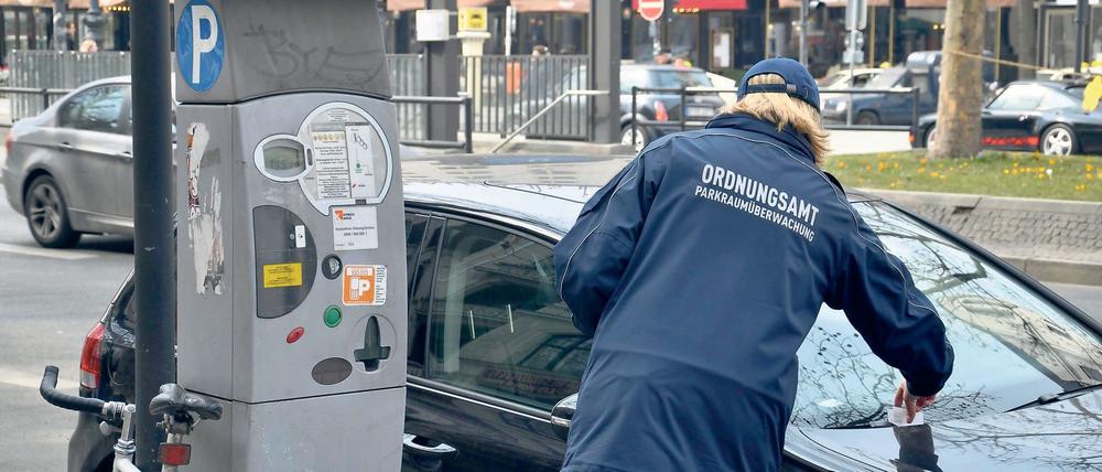 Ordnungsamt und Parksünder, Ordnungsamt, Frau, Parkraumüberwachung, Parkautomat, Auto, Parksünder, Knöllchen, Bußgeldbescheid Gesellschaft Ordnungsamt Strafzettel Symbolfoto GER Berlin xdp x0x 2013 quer