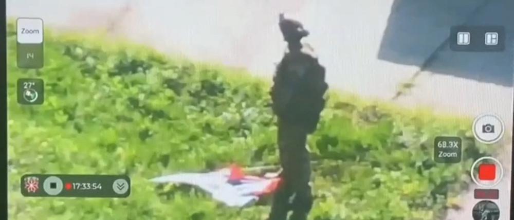 Ein Soldat in der Region Kursk neben einer russischen Flagge, die auf den Boden geworfen wurde