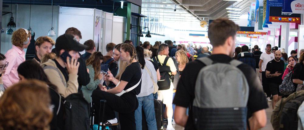 Reisende warten in der Halle des Flughafen Köln-Bonn auf ihr Weiterkommen.