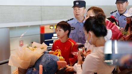 Quan Hongchan (l.) musste bei ihrer Ankunft von mehreren Beamten bewacht werden.