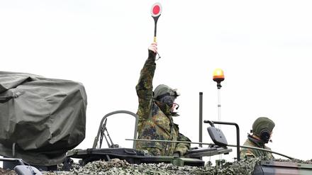 Ein Soldat auf einem GTK Boxer gibt mit der sogenannten Winkerkelle das Zeichen zum Abmarsch der Kolonne. 