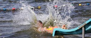 Wasser spritzt als ein Badegast im Strandbad in die Havel springt.