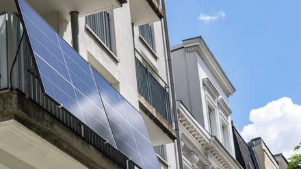 Eine Balkonsolaranlage hängt an einem Wohnhaus. Mit der richtigen Ausrichtung kann man kräftig Stromkosten einsparen.