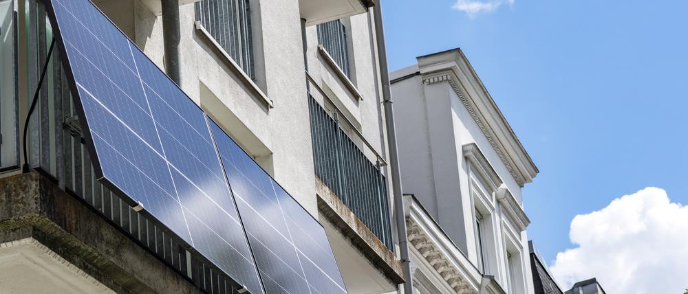 Eine Balkonsolaranlage hängt an einem Wohnhaus. Mit der richtigen Ausrichtung kann man kräftig Stromkosten einsparen.