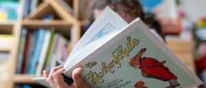 Ein Mädchen hält eine neuere Ausgabe des Kinderbuch-Klassikers „Die Häschenschule“.