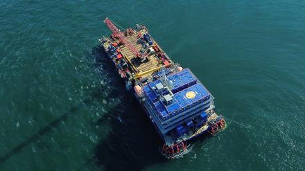 Eine Barge, ein flaches Schiff ohne eigenen Antrieb, wird über dem Wrack der „Verity“ platziert. 