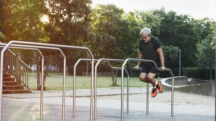 Ein Mann trainiert an einer Freiluft-Fitnessanlage (Symbolbild).