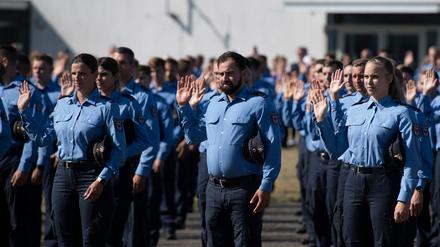 Angehende Brandenburger Polizeibeamtinnen und -beamte stehen anlässlich ihrer Vereidigung auf dem Gelände der Hochschule der Polizei in Oranienburg.