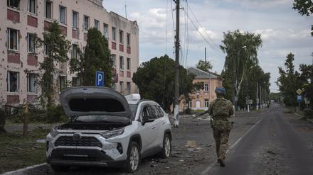 Ein ukrainischer Soldat geht am Rathaus in Sudscha vorbei. 