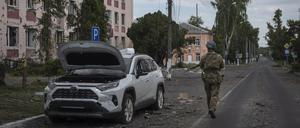 Ein ukrainischer Soldat geht am Rathaus in Sudscha vorbei. 