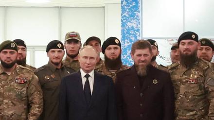 Der russische Präsident Wladimir Putin, das Oberhaupt der Tschetschenischen Republik, Ramsan Kadyrow, und russische Soldaten stellen sich bei einem Besuch der Universität der russischen Spezialeinheiten für ein Gruppenfoto auf.