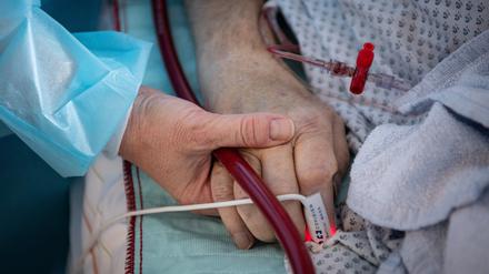 Eine Krankenschwester versorgt einen schwer erkrankten Patienten einer Intensivstation.