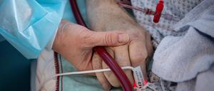 Eine Krankenschwester versorgt einen schwer erkrankten Patienten einer Intensivstation.