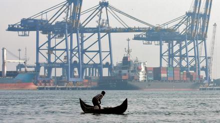 Rasante Veränderung: Ein Fischer im Vembanad-See mit dem Hafen der indischen Stadt Kochi im Hintergrund. 