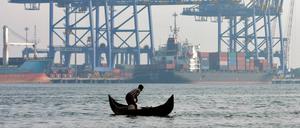 Rasante Veränderung: Ein Fischer im Vembanad-See mit dem Hafen der indischen Stadt Kochi im Hintergrund. 