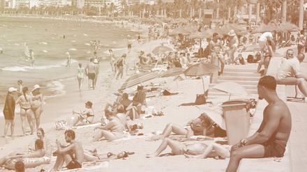 Touristen genießen einen warmen Sommertag am Strand von Arenal.