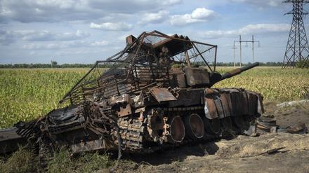 Ein zerstörter russischer Panzer liegt am Straßenrand.
