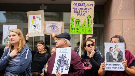 Teilnehmer des Protests der „Bürgerinitiative für ein Potsdam ohne Garnisonkirche“ halten anlässlich der Eröffnung des Turms der Garnisonkirche Schilder und Plakate. 
