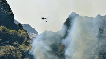Ein Hubschrauber fliegt über das Waldbrandgebiet auf Madeira. 