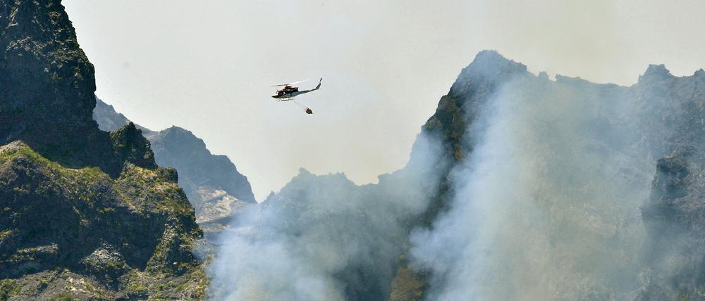 Ein Hubschrauber fliegt über das Waldbrandgebiet auf Madeira.